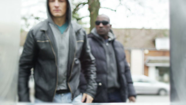 Suspicious characters take money from an ATM machine with a stolen card