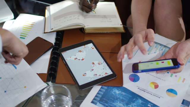  Hands using computer tablets in a business meeting no faces can be seen
