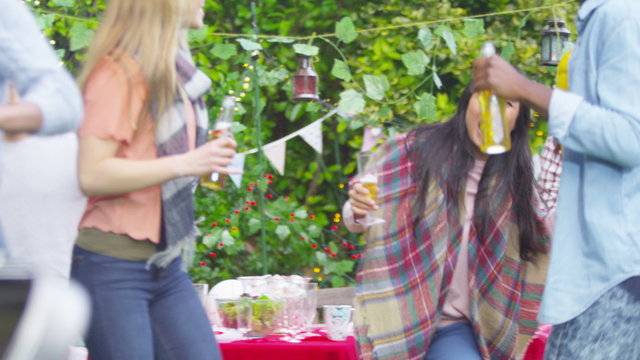  Happy mixed ethnicity group of dancing & drinking beer at bbq party