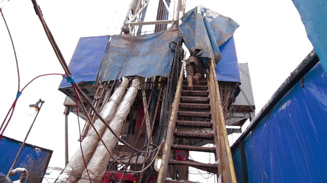 A driller climbing stairs drilling oil rig