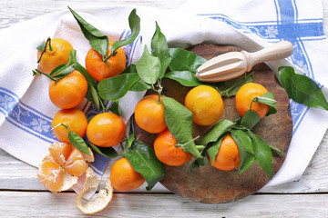 Mandarins with leaves on white towel 