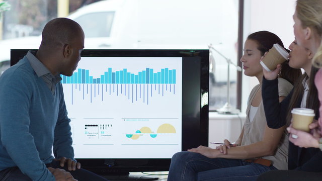  Young multi ethnic group of professionals discussing business results