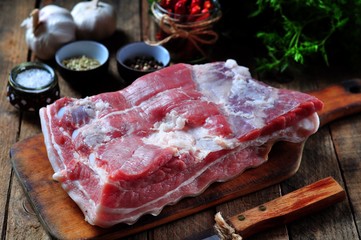 raw pork belly with salt, pepper, chili, fennel seeds, garlic, parsley and dill. rustic style.