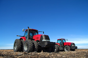 Obraz premium Two tractor cultivating the land