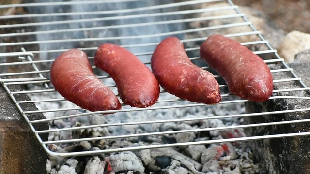 Turkish Sausage ( Sucuk ) cooking on the grill over coals.  
