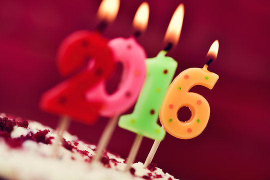 lit number-shaped candles forming number 2016 on a cake