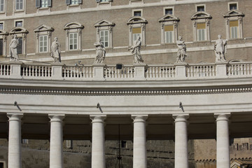 Architectural close up of the colonnade in Saint Peters Square in Vatican City, with statues on the terrace