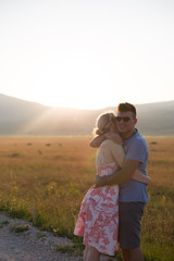 Young beautiful couple on the background of sunset