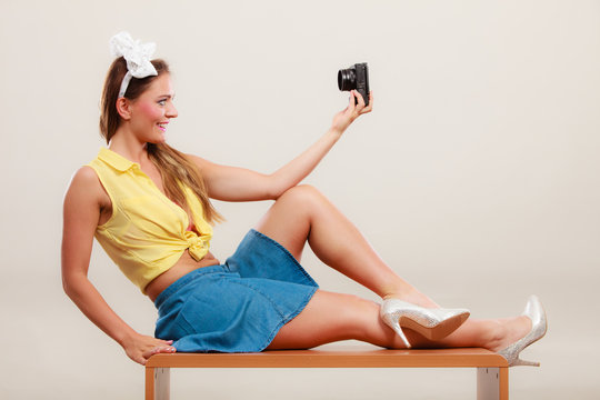 Pin up girl woman taking selfie photo with camera.
