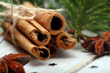 Cinnamon sticks and anise stars with decoration on wooden backgr
