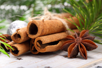 Cinnamon sticks and anise stars with decoration on wooden backgr