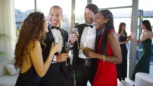  Attractive group of elegant friends drinking champagne at boat party