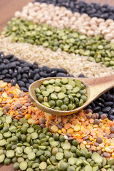 Split peas on wooden spoon.