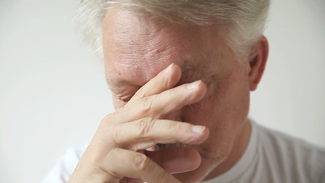Senior man shows signs of fatigue and eyestrain.