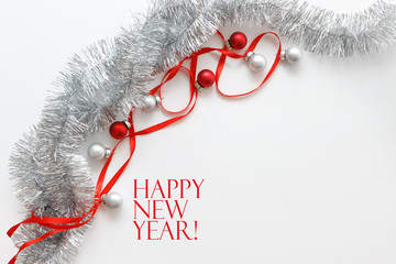 Greeting card template made of red ribbon, silver tinsel and balls with copy space, horizontal view, selective focus