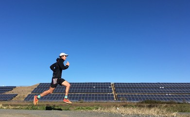 Man running past solar energy farm