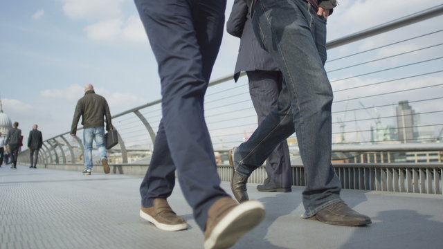  Low angle view of feet walking across a London bridge with St. Paul's Cathedral in background