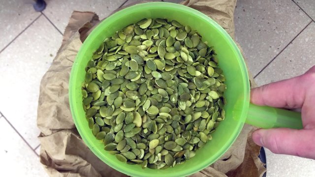 Scooping pumkin seeds from a bag, at a restaurant bakery kichen