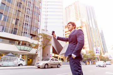 Businessman catching taxi in city