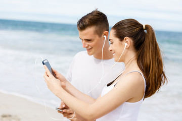 Couple of runners with mobile smart phones outdoors