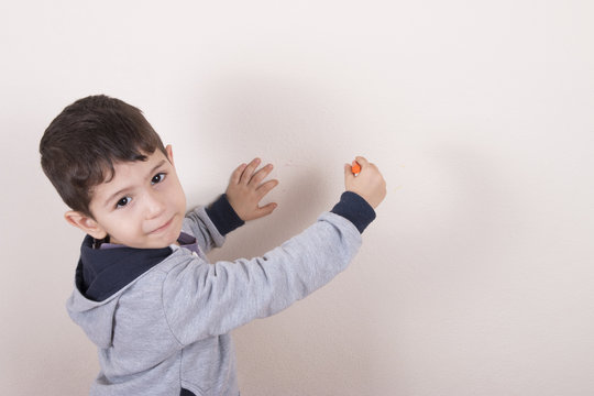 çocuk pastel boya ile duvarı çiziyor