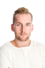 Obraz premium An attractive man in his 20s wearing a white sweater standing against a white background smiling against camera.