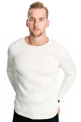 Fototapeta premium An attractive man in his 20s wearing a white sweater standing against a white background smiling against camera.