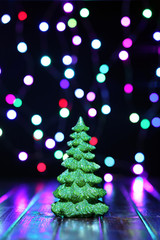 Little Christmas tree in front of lights