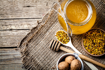 glass of fresh honey isolated and walnuts in a bucket