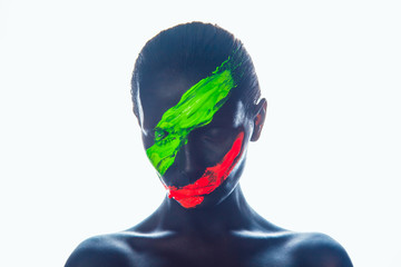 Girl with a black paint on the face. Green and red stripes.