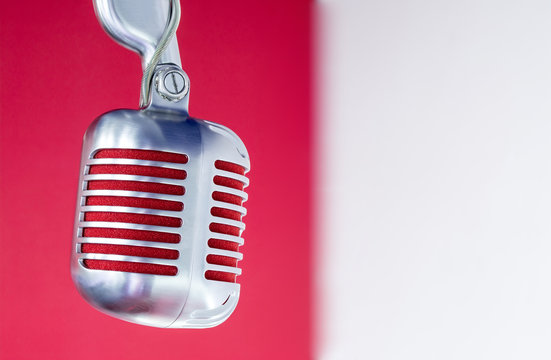silver vintage microphone with red membrane on a red-white background