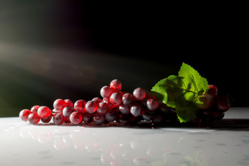 bunch of grapes in the sun on a dark background
