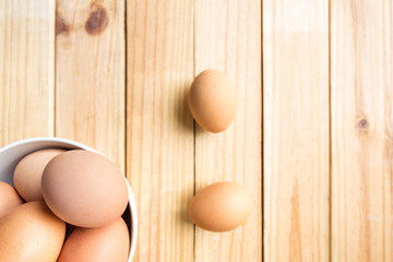 hen eggs in bowl on wood plate