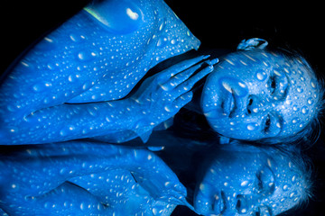 The  body of woman with blue pattern and its reflection