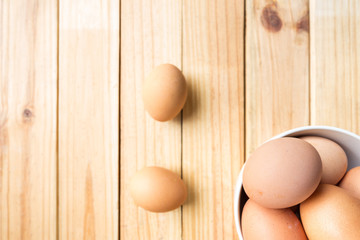 hen eggs in bowl on wood background