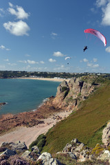 Fototapeta na wymiar Hanggliders above Saint Brelades Bay, Jersey