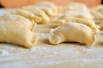 Fototapeta na wymiar Preparing fresh polish pierogies pasta. Rustic style. Close-up, shallow depth of field.