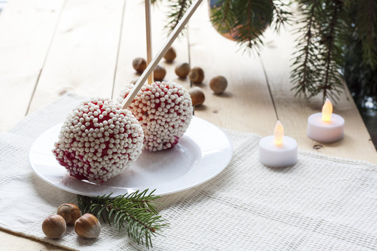 Apples in caramel with rice balls coating on Christmas and New Year background decor closeup