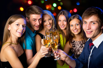 Young friends touching the glasses with each other