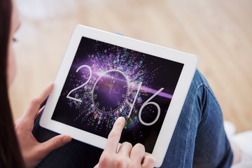 Composite image of teen using a tablet pc sitting on the floor