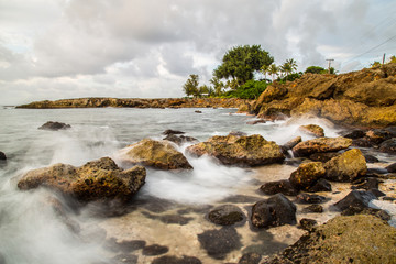 Sunset at Shark's Cove Beach with rocky shore