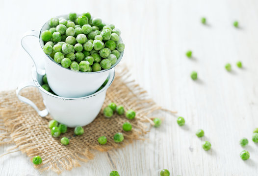 frozem peas on wooden surface
