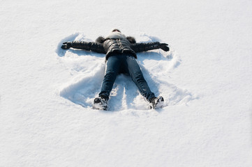 Fototapeta na wymiar Girl in the snow making angel