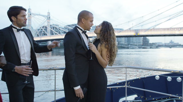  Romantic couple in love kiss on the deck of a party boat on River Thames