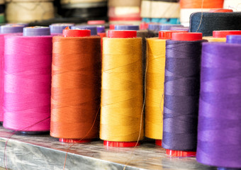 Spools of Colorful Cotton Thread on Metal Shelf