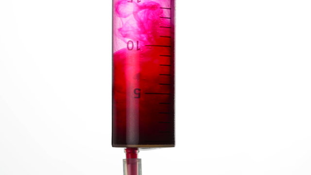 Close-up of a syringe being drawned up with blood.