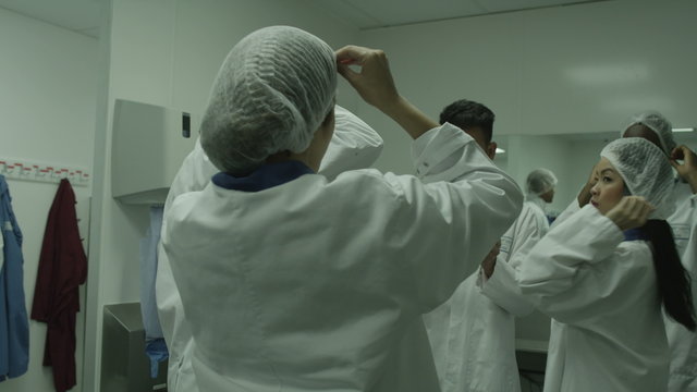  Workers in clean room prepare to start work on factory floor