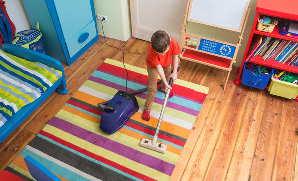 boy cleaning  floor with hoover
