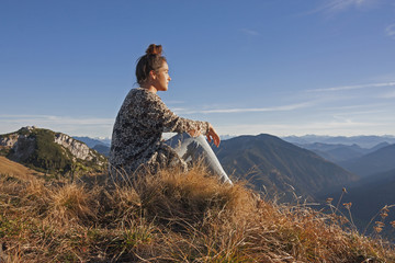 Junge Frau genießt die Aussicht am Wendelstein, Abendstimmung