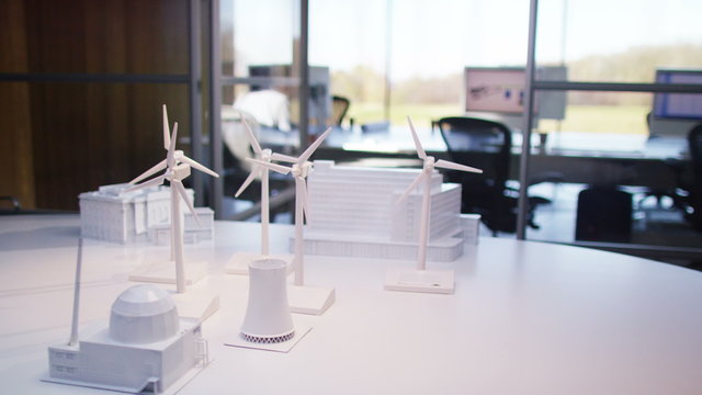 Concept models of buildings and wind turbines on a desk in empty office